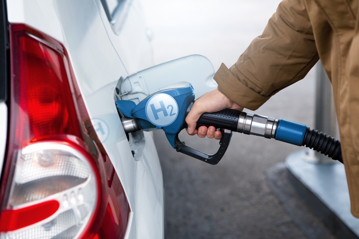 Eine Person tankt ein Auto mit Wasserstoff