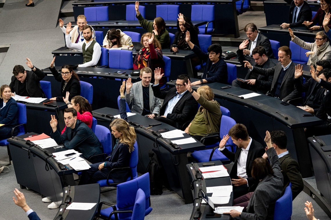 Abgeordnete geben Handzeichen zur Abstimmung im Plenarsaal des Bundestages