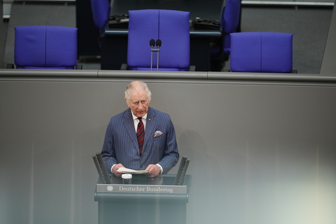 König Charles steht im Plenarsaal.