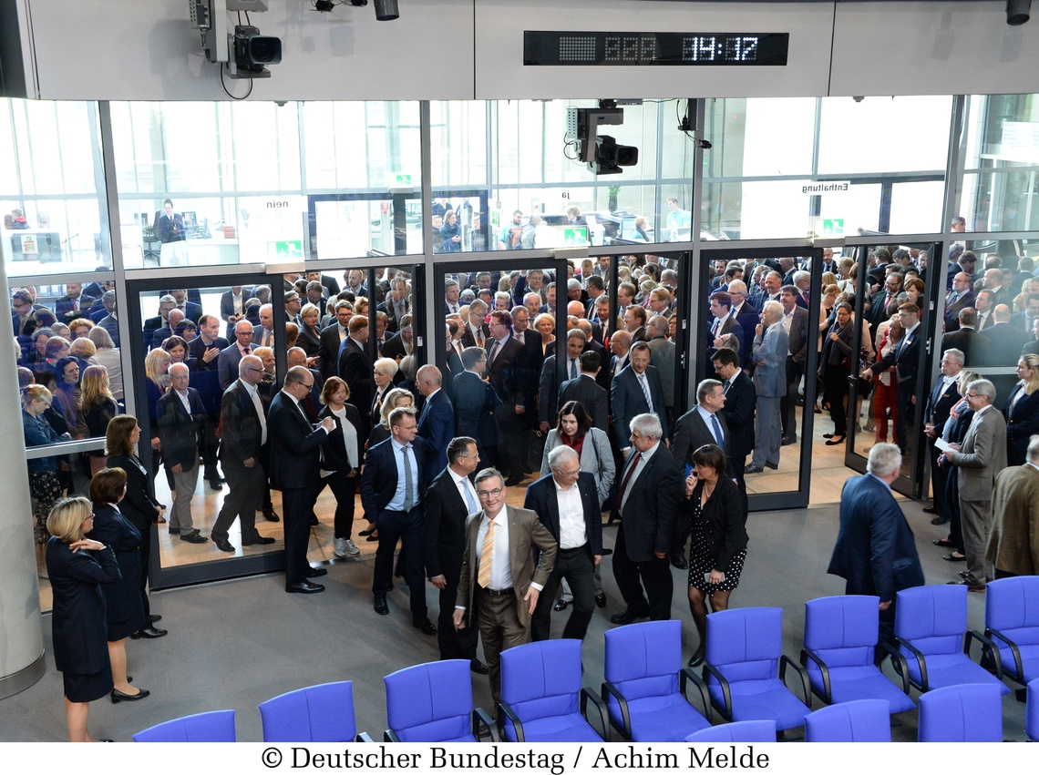 Verschiedene Menschen stehen an einer Tür