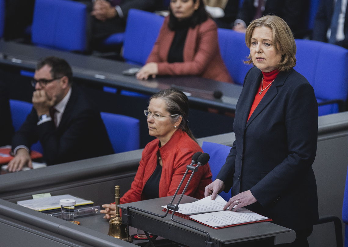 Bundestagspräsidentin Bas steht an ihrem Platz im Plenarsaal, im Hintergrund eine Schriftführerin und die besetzte Regierungsbank