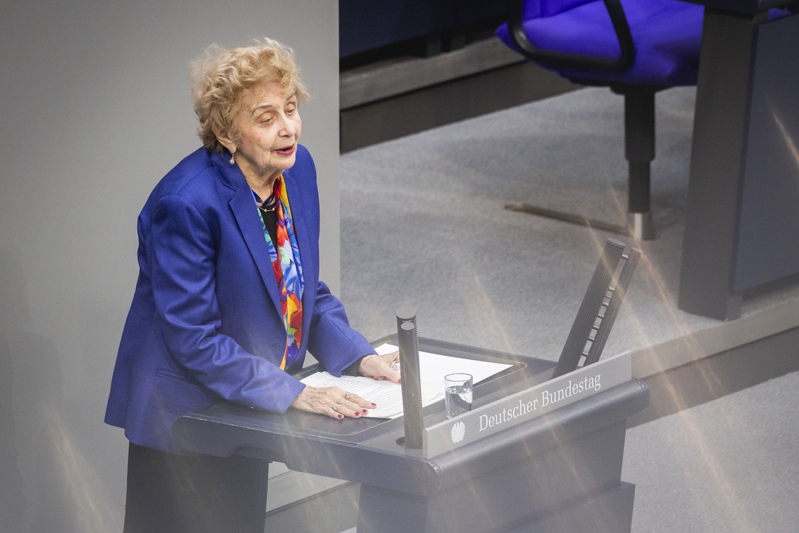 Tova Friedmann steht am Rednerpult im Deutschen Bundestag und hält eine Rede. Vor ihr liegen Unterlagen, daneben steht ein Glas Wasser.