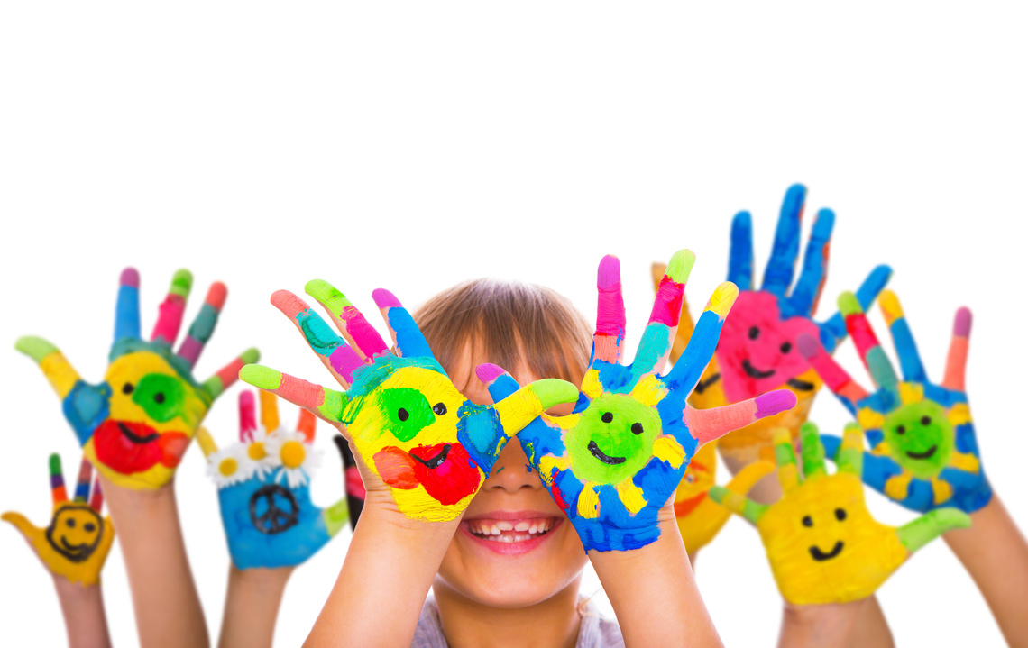 Ein Foto mehrerer kunterbunt bemalter Kinderhände mit lachenden Gesichtern; ein Kind hält sie vor sein lächelndes Gesicht.
