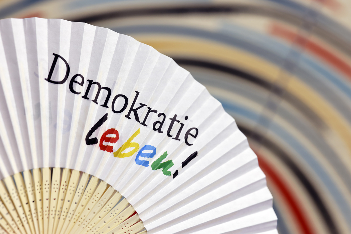 Weißer Fächer mit dem Schriftzug "Demokratie leben".
