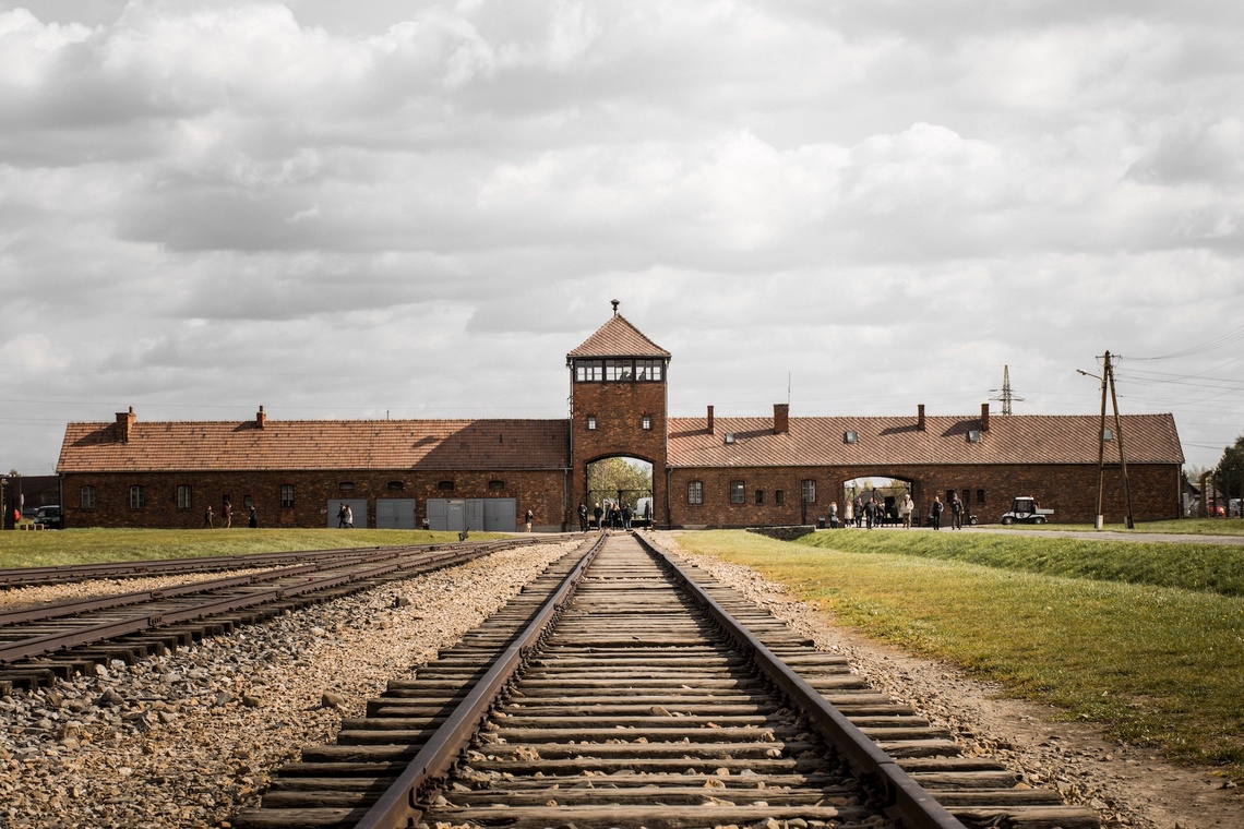Bahnschienen, die zum Wachturm des ehemaligen Konzentrationslager Auschwitz-Birkenau führen.