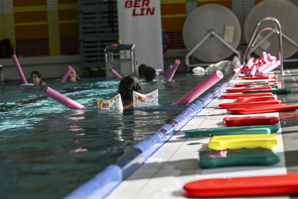 Schwimmbadbecken mit Kindern und Schwimmhilfen