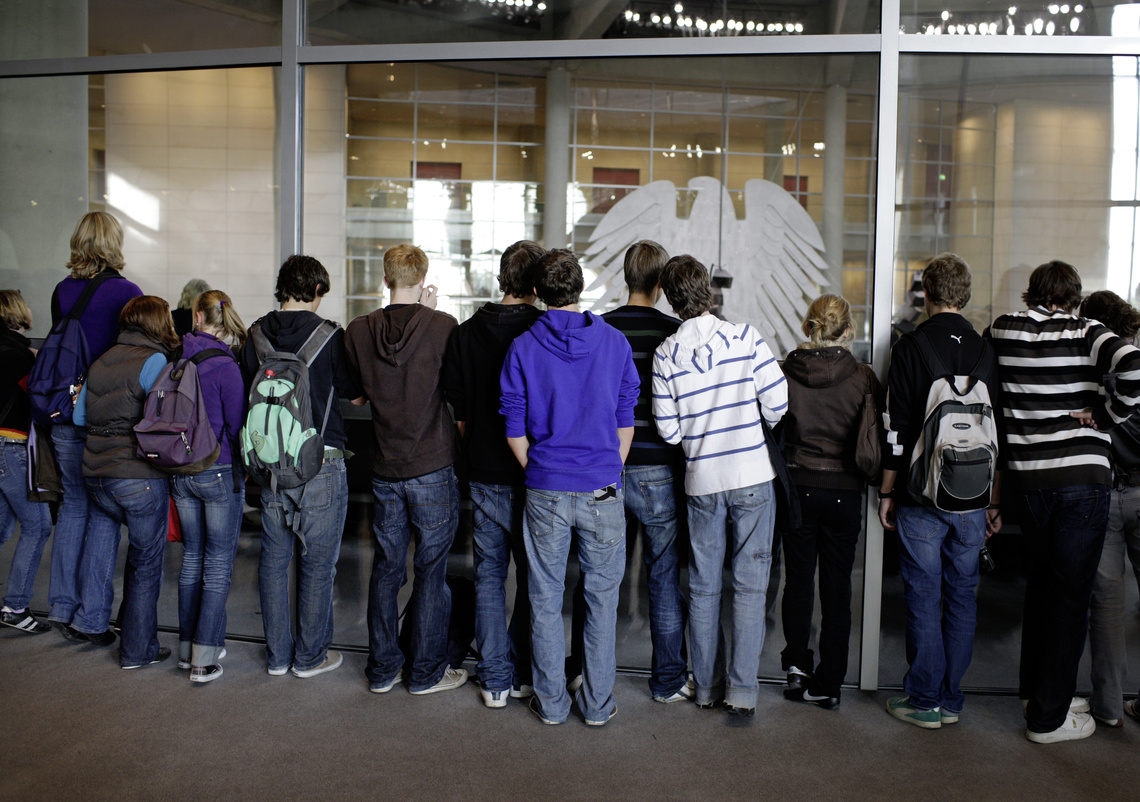 Gruppe mit Kindern schaut durch Fenster in den Plenarsaal