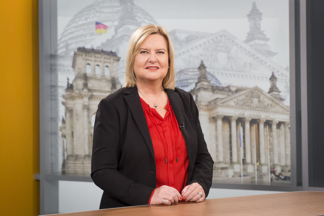 Portrait der Wehrbeauftragten Eva Högl vor einer Abbildung des Reichstagsgebäudes 