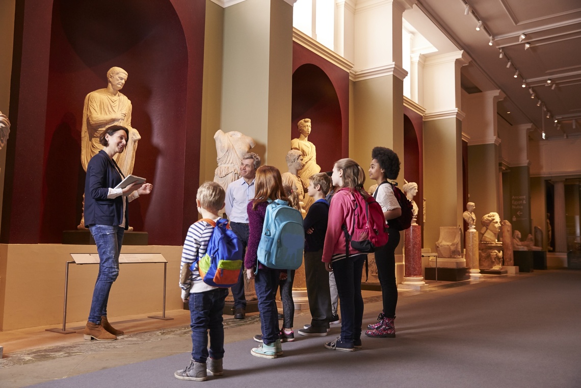 Eine Gruppe Kinder und eine Frau im Museum.