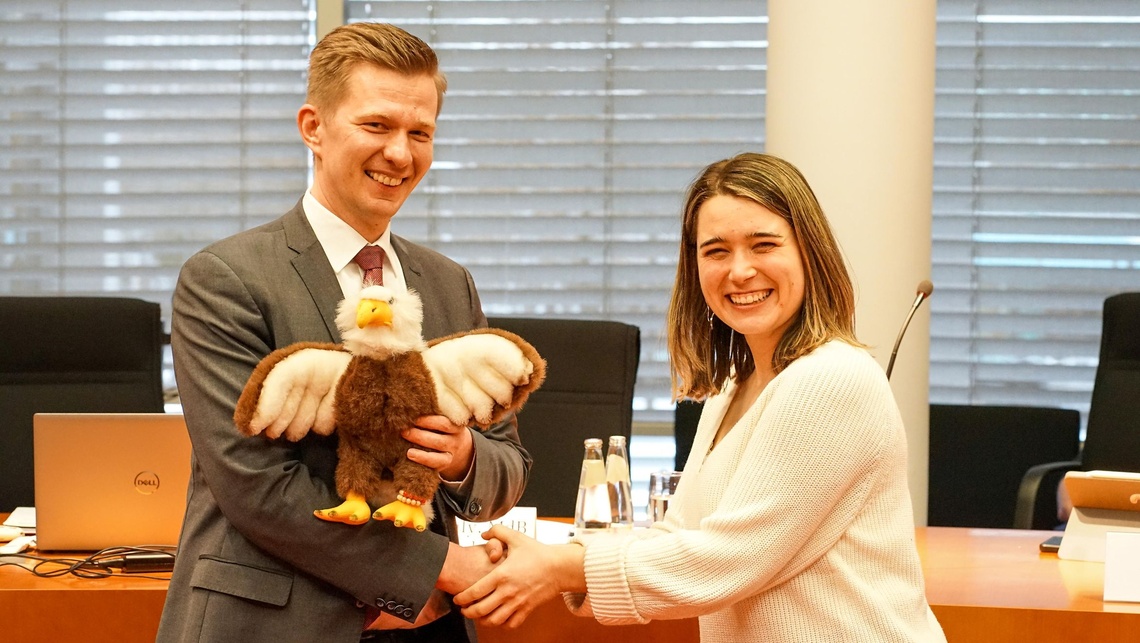 Emilia Fester (Bündnis 90/Die Grünen) gratuliert Matthias Seestern-Pauly (FDP) zum Vorsitz der KiKo und überreicht ihm das Kiko-Maskottchen. 
