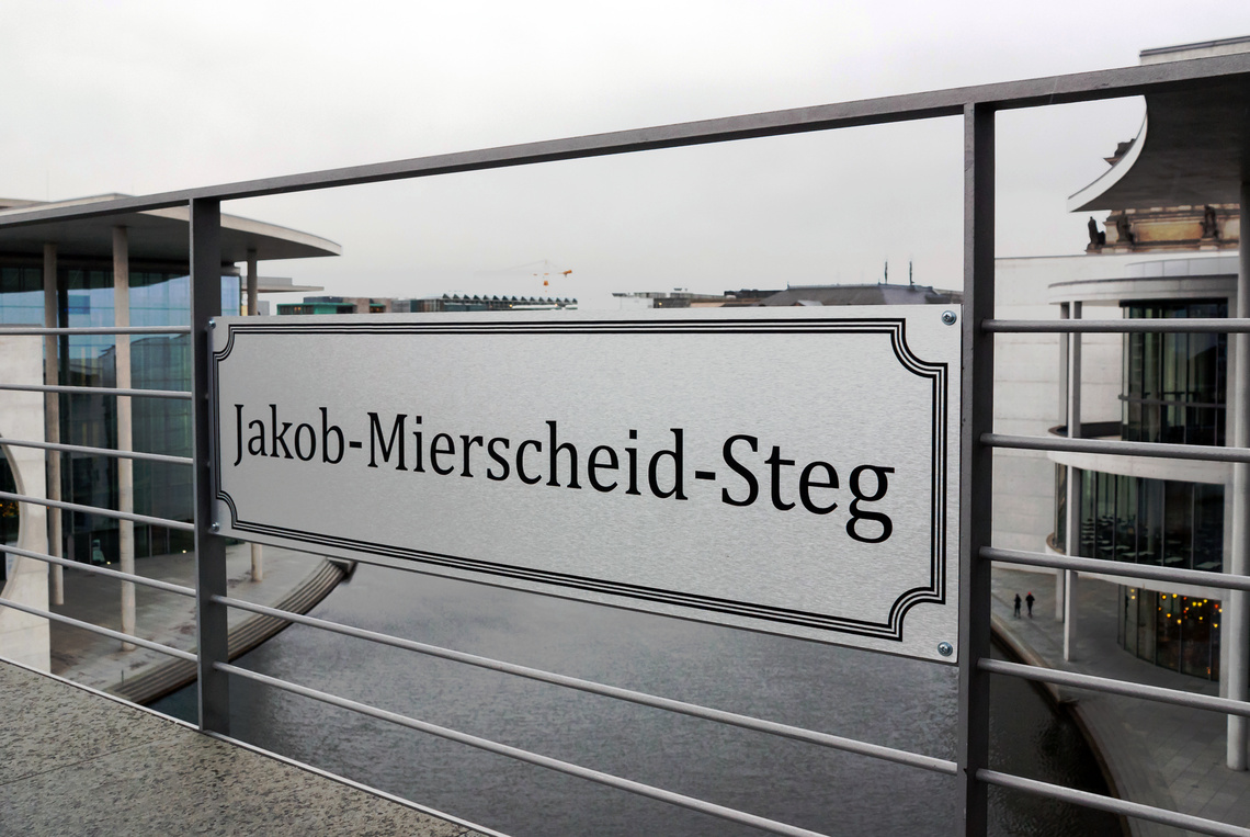Schild mit Jakob-Mierscheid-Steg am Geländer über der Spree