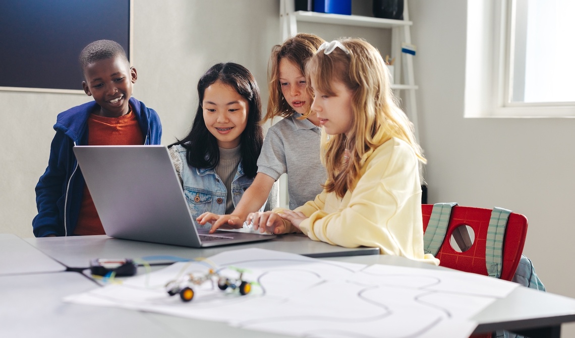 Kinder arbeiten zusammen an einem Laptop