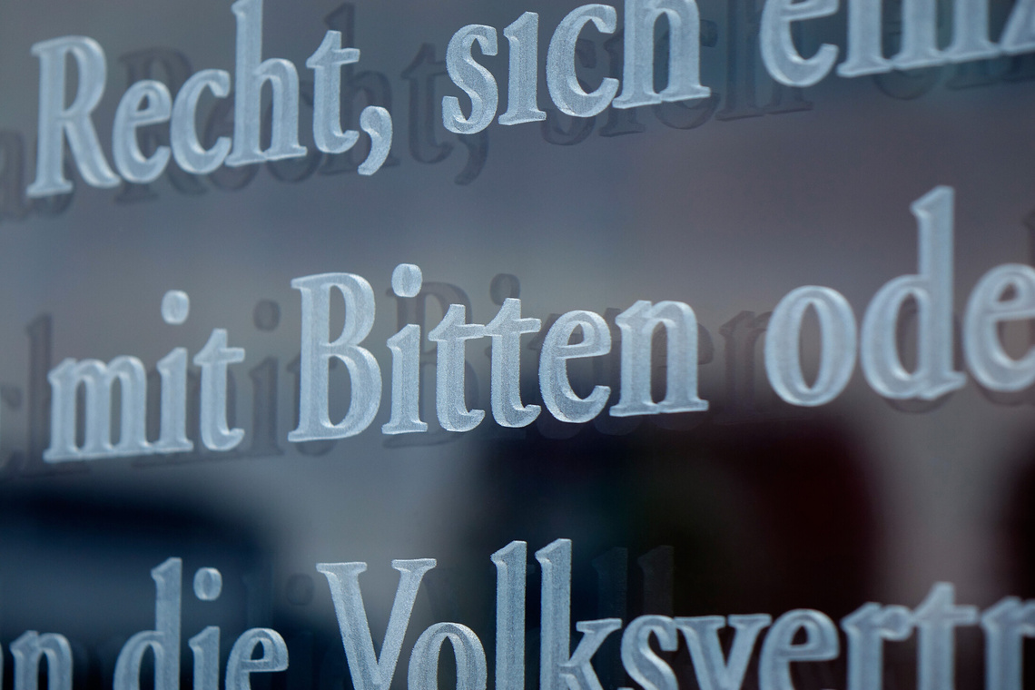 Glastafel mit eingravierten Worten zu Petition