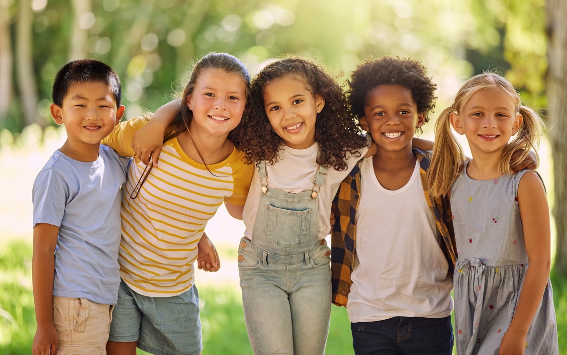 Fünf Kinder lächeln in die Kamera.