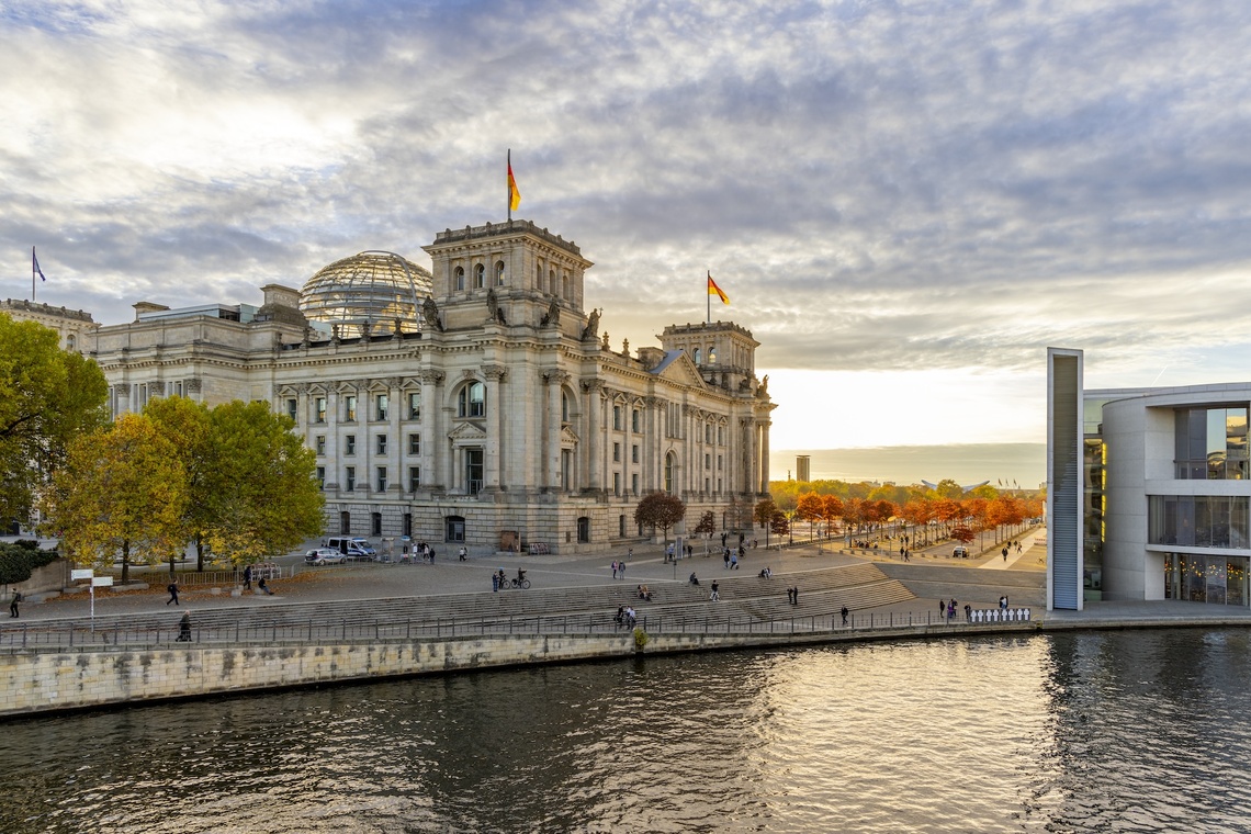 Die Außenansicht des Deutschen Bundestages mit der Spree im Vordergrund.