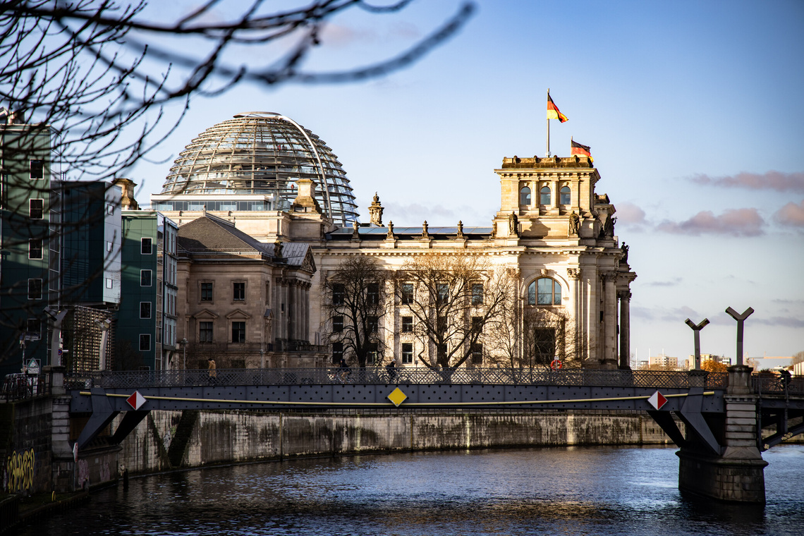 Blick auf Reichstagsgebäude mit Spree und Brücke im Vordergrund