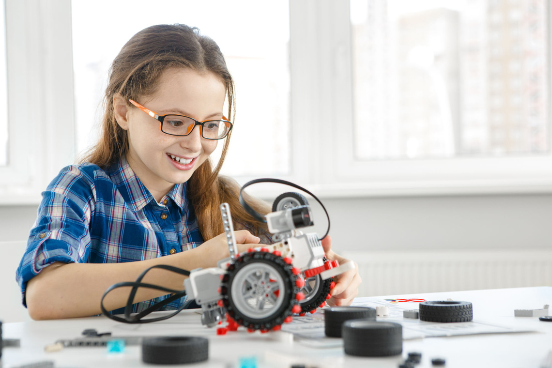 Mädchen baut einen Roboter zusammen.
