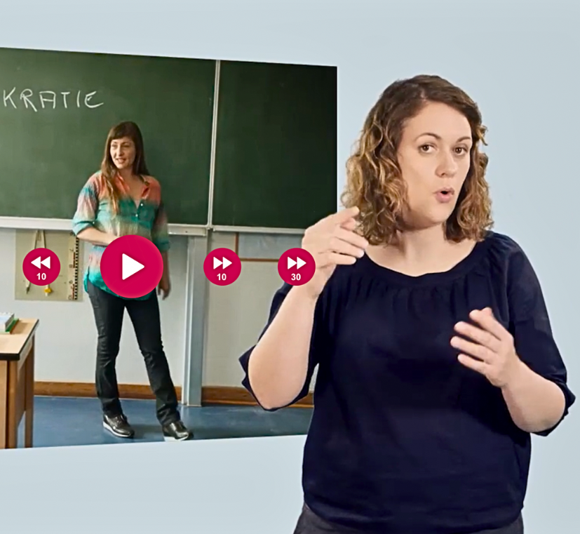 Lehrerin Steht vor Tafel, Gebärdenübersetzerin ist im Vordergrund, Screenshot vom Player